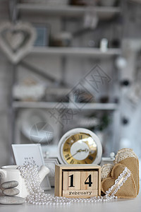 2月14日情人节定的木板日历旁边的心脏 白钟在桌子上和明室背景 (日期 2月14日)图片