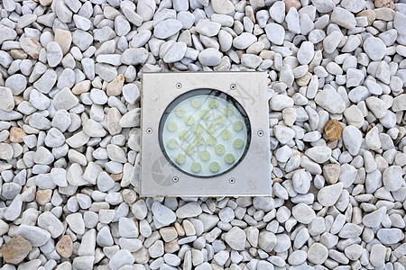 花园白色碎石上现代圆形灯的内置图片