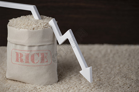 大米收成 贫苦的农作物 粮食短缺 世界饥饿 一袋棕色背景的大米 白箭指向下出口种子商业产品危机生长农业危险价格市场图片