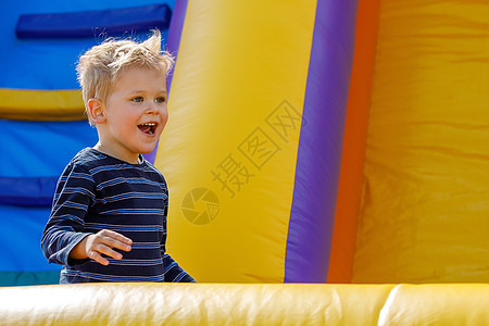 幼稚园生日派对上 小孩在充气弹跳城堡跳跃 活动与游戏中心为幼儿服务 夏天小笑男孩户外玩耍图片