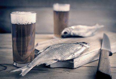 两杯啤酒和干鱼桌子夫妻眼镜蟑螂啤酒杯盐渍美味砧板啤酒瓶食物图片