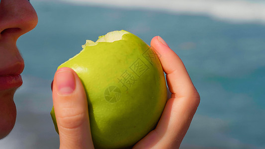近距离咬女人 吃成熟的绿苹果图片