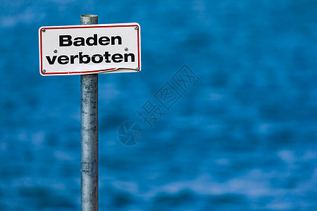红色边框德文标志没有在湖前的一根柱子上游泳 有蓝水背景