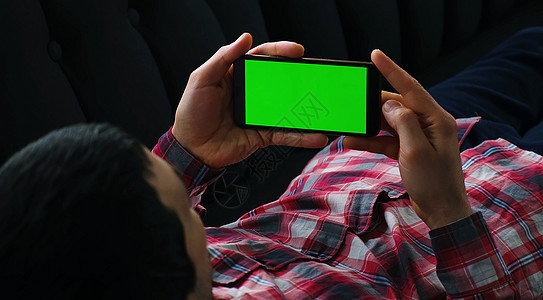 一个人手里拿着一个带绿屏的手机 有选择地集中注意力电话药片监视器手指技术男性触摸屏展示蓝色商业图片