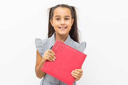 小女孩拿着一本大书 孤立在白色背景上精装智力蓝色学生女学生眼睛女性童年小姑娘青少年图片