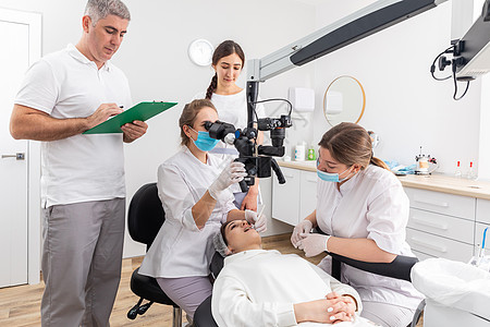 牙科诊所的一组学生学习用显微镜观察牙科治疗手术办公室器材教育牙齿药品乐器口服外科关心图片