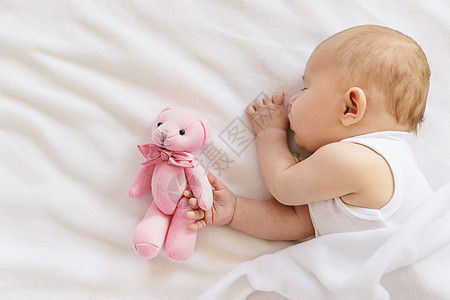 80后玩具婴儿睡在白色背景上的泰迪熊 有选择的焦点横幅女孩男生毯子友谊睡眠婴儿床玩具说谎新生背景