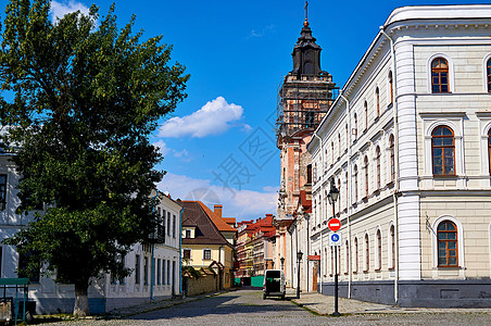 在中世纪城市的一条小轻型行人街道上 有一座教堂钟楼图片