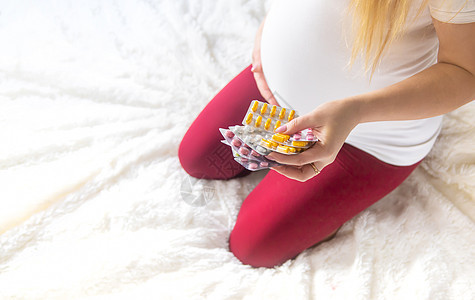 孕妇手里握着许多药丸 有选择的焦点母性女性疼痛成人生活横幅治愈压力药品怀孕图片