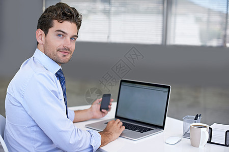 良好的客户沟通是他的首要任务 一位年轻商务人士坐在办公桌前 手里拿着手机的画像生意人高清图片素材
