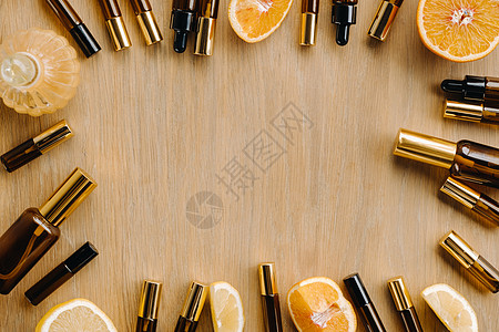 瓶子和柠檬中的必要油 木质表面的橙子水果治疗芳香写作木头血清琥珀色药品香水液体图片