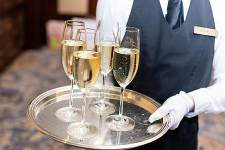 在派对上 服务员拿着装着香槟杯的托盘图片