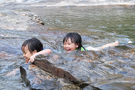 身穿救生衣的亚洲可爱儿童在河里玩乐 两个小姐妹在河里游泳很愉快 “孩子们健康暑假活动”一书图片