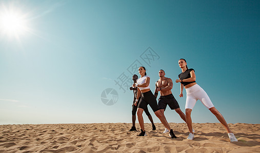 尊巴舞 团队健身和运动理念 一群四名年轻的男女运动员 健康的运动员站在天空背景上背景图片