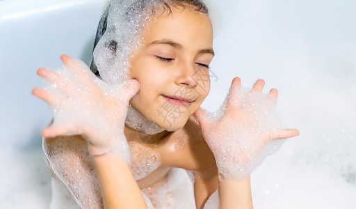 孩子在浴缸肥皂水里洗澡 有选择的焦点飞溅微笑泡沫浴室女孩乐趣游泳肥皂洗发水卫生图片