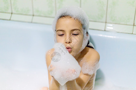 孩子在浴缸肥皂水里洗澡 有选择的焦点泡沫卫生微笑幸福女性女孩婴儿洗发水男生飞溅图片