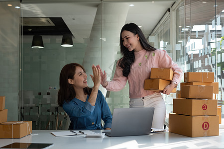 商业数字在线是小型企业目前在线商店的新起点 由两位女店主拥有一个仓库 用来给客户送货 中小企业企业家理念电脑商务技术互联网纸板成图片