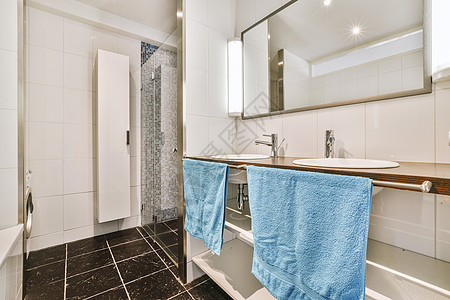 淋浴小屋附近的Sinks和浴缸卫生间建筑学白色镜子住宅毛巾龙头反射抽屉蓝色图片
