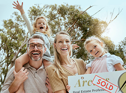 幸福的白人家庭在搬迁和搬进新房子时举着卖牌子的画像 微笑的父母和孩子为房地产和购房获得房主贷款图片
