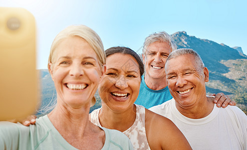 一群活跃的老年人在阳光明媚的日子里在山景背景下一起自拍或视频通话 快乐的退休人员一起在户外锻炼 过上健康和积极的生活方式图片