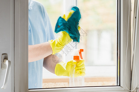 男子在黄色橡胶手套清洗窗内背景图片