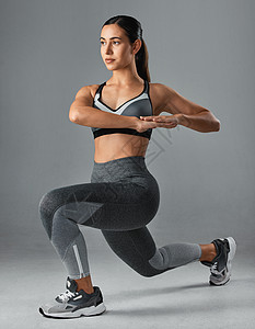 你愿意为结果做出牺牲吗？运动型年轻女子在灰色背景下锻炼的摄影棚照片图片
