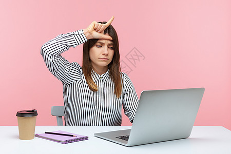 有情感的年轻女性 坐在办公室工作 有粉红色背景电话黑发讽刺手势危机职场商业失败前额悲伤图片