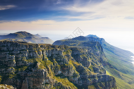 景观 蓝天与南非西开普省桌山的复制空间 风景秀丽的陡峭著名远足和徒步地形 山腰郁郁葱葱 对地标的旅行和旅游业图片