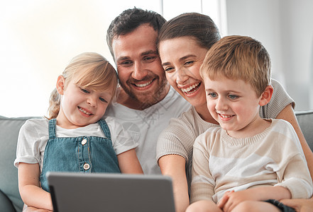 快乐的家是一个温暖的家 一个年轻家庭在家中用数字平板电脑拍摄的照片图片