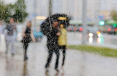 与带雨伞的人在窗口上的雨滴风暴环境气候行人天气液体温度团体飞溅雷雨图片