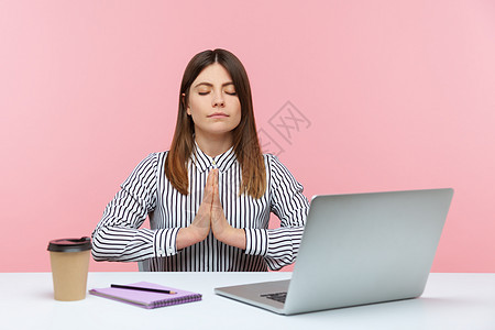 感恩有礼有情感的年轻女性 坐在办公室工作 有粉红色背景专注练习训练黑发冥想笔记本女士商业瑜伽休息背景
