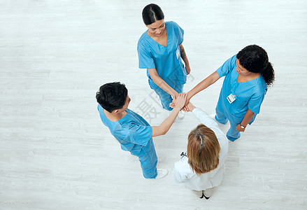 一群医疗从业者手牵手并肩合在一起 胜于一杆的光芒图片