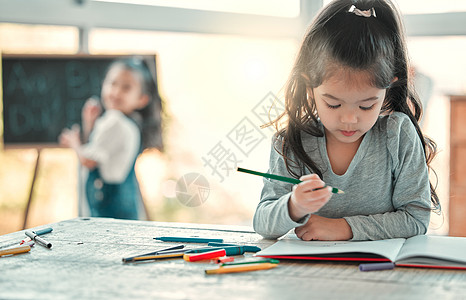 我喜欢玩彩色 一个可爱的小女孩在桌子上做美术作品背景