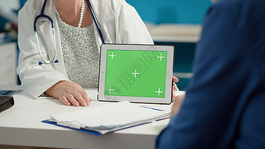 保健专家在数字平板电脑上持有横向绿色屏风图片