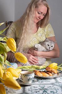 金发的中年金色抱小猫 喝茶 黄郁金香和书友谊乐趣动物折叠伴侣拥抱静物压痛猫咪女性图片