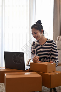 网上年轻女性卖方准备将产品包裹箱交付给客户的在线青年销售商图片