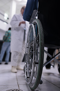 利用私人诊所接待处的轮椅 与医生交谈时使用轮椅对残疾老年男子进行近距离检查图片