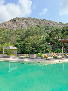 保护伞和环绕户外游泳池的椅子 旅馆度假村近海滨图片