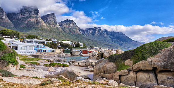 在著名的旅游或旅游目的地与住宅的山 海和海滩岩石景观 南非开普敦坎普斯湾风景秀丽的十二使徒岩 蓝天白云图片