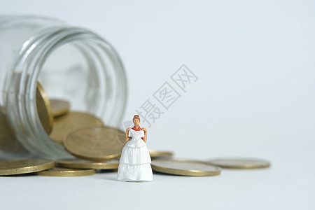 新娘的婚纱预算 微型人物插图概念 妇女站在硬币钱罐之上 图像图片照片婚姻金融债务贷款经济储蓄马夫女士硬币传统图片