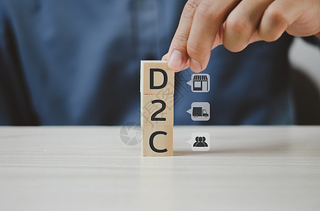 手把木制立方体直接对消费者D2C和图标放在桌子上 复制空间 商业概念图片