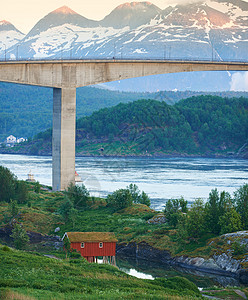 冬季挪威诺德兰桥的景观 以雪山为背景的河流或溪流上的交通基础设施景观 海外偏远小屋图片