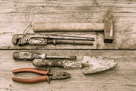 旧的有色锤子 可调整的扳手 螺丝起子 和木板上的钳子图片