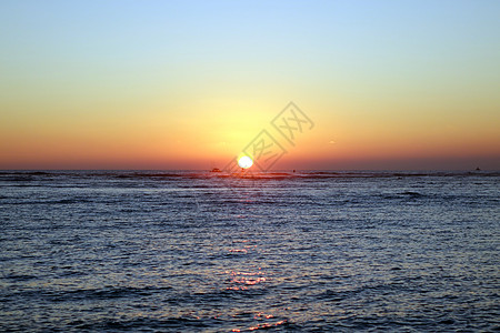 日落期间在海面上浮着船和浮标环境冲浪者日出海岸木板太阳假期热带海洋游客图片