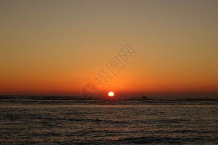 日落期间在海面上浮着船和浮标海岸海景天堂游客热带假期环境太阳海洋日出图片