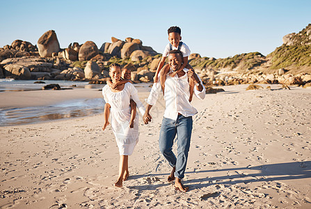 年轻的非洲裔美国父母手牵着手 带着他们的两个孩子 沿着海滩散步的全长肖像 有小女儿和儿子的年轻家庭共度时光 享受假期孩子们女士男图片