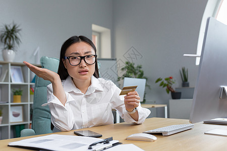 一名失望的年轻女士因为诈骗而失去了毕生积蓄 坐在办公室办公桌前享受情感卡片金融互联网银行业电脑风险安全技术图片