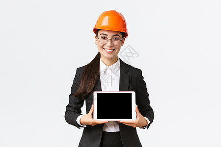微笑的亚洲专业女建筑师介绍她的项目 工程师在数字平板电脑显示器上展示图表 在企业或工厂进行演示 站在白色背景电子商务雇主房地产人图片