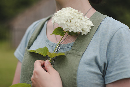 园艺和职业概念     夏季在花园里盛花的围裙女青年农场花园工作幸福季节工人植物温室园丁生长图片