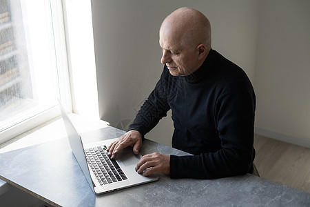 穿着聪明随意风格的英俊老男人正在用笔记本电脑职场男性工作微笑男人商业头发人士成人办公室图片